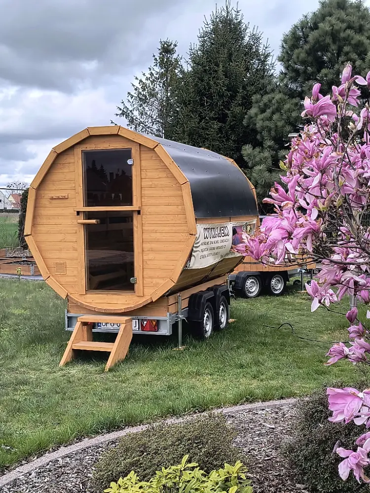 Sauna mobilna zaparkowana obok kwitnącej magnolii