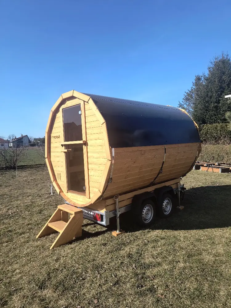 Beczkowa sauna mobilna na tle bezchmurnego nieba